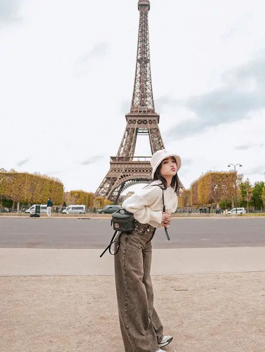 Berlibur di Paris, Fuji An memilih mengenakan atasan putih crop top dengan inner serasi dengan bucket hatnya. Ia memadukannya dengan celana denim dan sneakersnya. [@fuji_an]