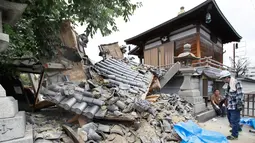 Gerbang Kuil Myotoku-ji runtuh setelah gempa bumi melanda Kota Ibaraki, Osaka, Jepang, Senin (18/6). Kyodo News Agency melaporkan bahwa seorang gadis cilik  dan lansia tewas tertimpa reruntuhan. (Yosuke Mizuno/Kyodo News via AP)