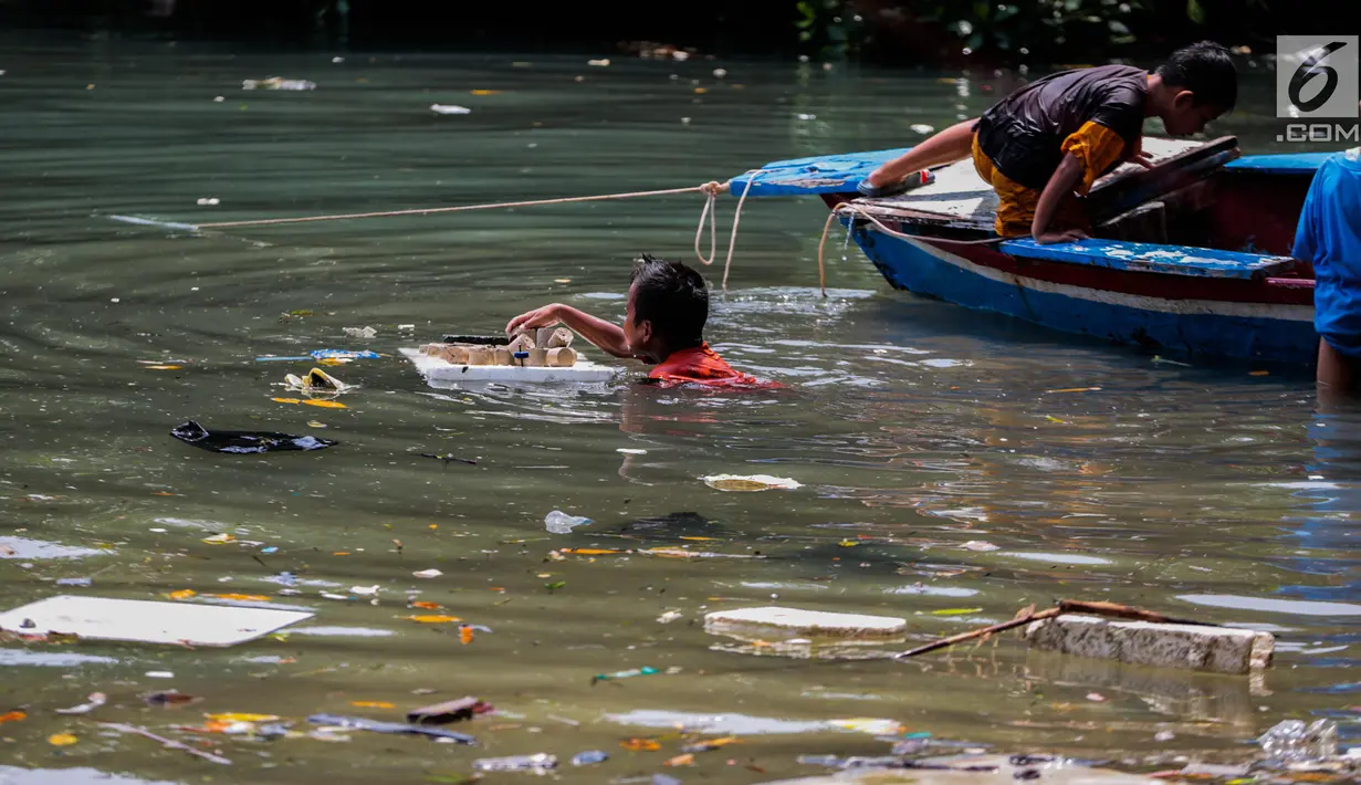 Anak-anak bermain di antara sampah kiriman yang mengotori perairan Kepulauan Seribu di sekitar Pulau Pari dan Pulau Pramuka, Rabu (28/11). Sampah berasal dari wilayah luar Jakarta yang terbawa angin hingga ke perairan Jakarta. (Liputan6.com/Faizal Fanani)