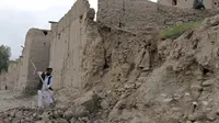 Seorang lelaki membersihkan puing bangunan yang runtuh akibat gempa di Jalalabad, Afghanistan, Senin (26/10/2015). Sekitar 43 orang dipastikan tewas akibat lindu berkekuatan 7,5 skala Richter tersebut. (REUTERS/Parwiz)