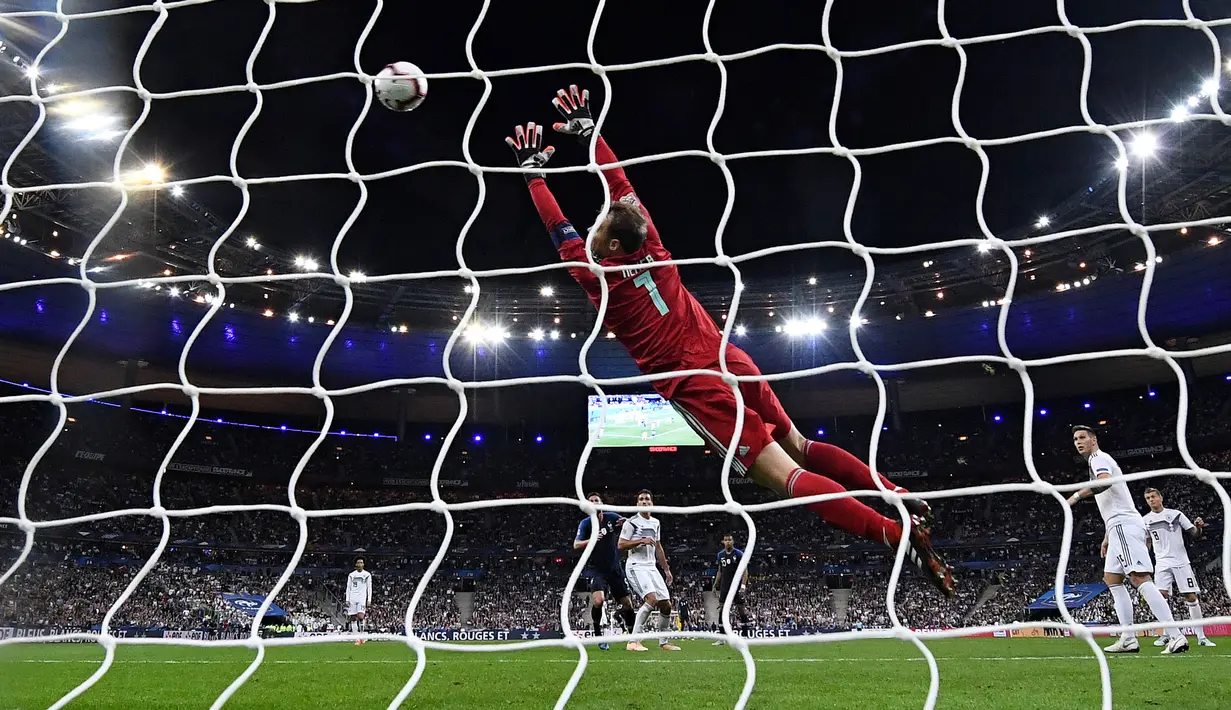Penjaga gawang Jerman, Manuel Neuer gagal menepis penalti Antoine Griezmann saat menghadapi Prancis pda UEFA Nations League di Stadion Stade de France, Paris, Selasa (16/10). Dua gol Griezmann membawa Prancis menaklukkan Jerman 2-1. (FRANCK FIFE/AFP)