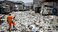 Petugas UPK Badan Air DKI melihat sampah yang menumpuk di Kali Gendong, Penjaringan, Jakarta Utara, Kamis (16/3). Ceceran sampah plastik limbah rumah tangga terlihat menyerupai daratan menumpuk di sepanjang Kali Gendong. (Liputan6.com/Faizal Fanani)