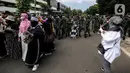 Prajurit TNI menghalau massa yang hendak menggelar demonstrasi 1812 di sekitar Istana Negara, Jakarta, Jumat (18/12/2020). Demo bertajuk Aksi 1812 ini selain menuntut pembebasan Rizieq Shihab, juga mendesak pengusutan kasus enam anggota FPI yang tewas tertembak polisi. (Liputan6.com/Johan Tallo)