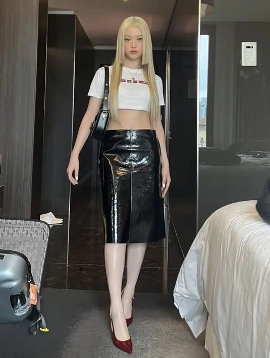 Hanni NewJeans hadir di fashion Show Gucci, ia tampil mengenakan crop top putih dipadukan midi skirt hitam dan stiletto heels maroon. Dengan tampilan baru rambut blondenya. [@newjeans_official]