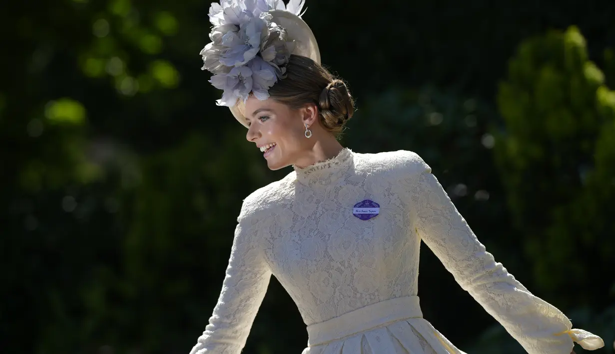 Rosie Tapner mengenakan topi bunga berpose setelah tiba untuk hari pertama acara balap kuda Royal Ascot, di Ascot Racecourse, di Ascot, Inggris, Selasa (14/6/2022). (AP Photo/Alastair Grant)