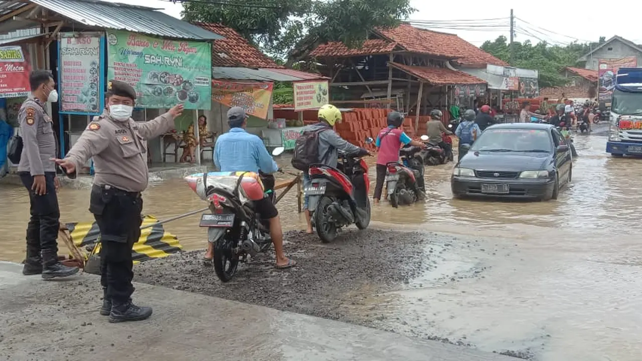 Polisi mengatur lalu lintas yang macet akibat banjir Bangkalan. (Dian Kurniawan/Liputan6.com)