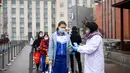 Para murid berbaris untuk melakukan pemeriksaan suhu tubuh di Sekolah Menengah Pertama No. 87 di Changchun, Provinsi Jilin, China timur laut, (20/4/2020). Lebih dari 56.000 pelajar tahun akhir sekolah menengah pertama di Changchun kembali masuk sekolah pada Senin (20/4). (Xinhua/Yan Linyun)