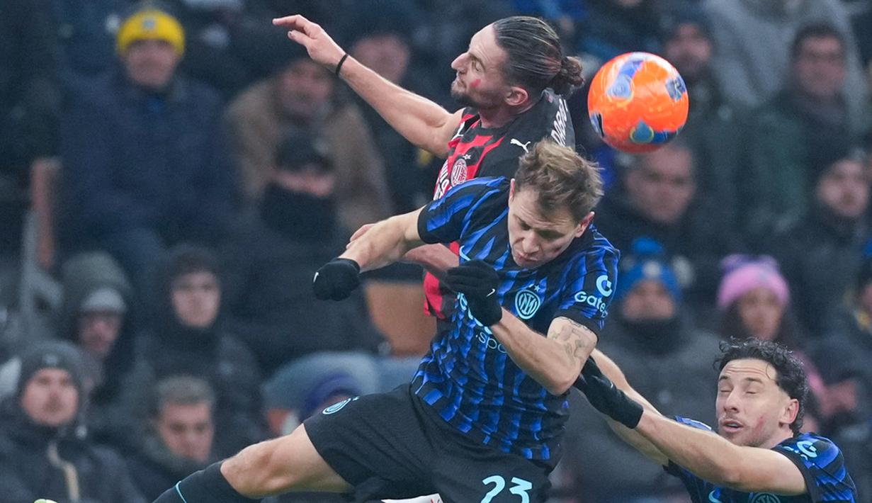 Pemain AC Milan, Adrien Rabiot, duel udara dengan pemain Inter Milan, Nicolo Barella, pada laga Italia di Stadion Giuseppe Meazza, Senin (2411/2025). (AP Photo/Antonio Calanni)