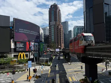 Sebuah monorel bergerak melalui distrik perbelanjaan kosong di pusat kota Kuala Lumpur, Malaysia, Senin, (4/5/2020). Banyak sektor bisnis dibuka kembali pada Senin di beberapa bagian Malaysia sejak penguncian sebagian virus dimulai 18 Maret. (AP/Vincent Thian)