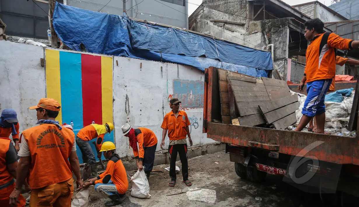 Petugas kebersihan mengangkat puing-puing sisa pembongkaran kios di sepanjang Jalan Jatibaru X, Tanah Abang, Jakarta, Minggu (3/5/2015). Pembongkaran dilakukan karena kios tersebut menutupi saluran air . (Liputan6.com/Faizal Fanani)