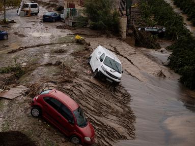 Mobil-mobil terperosok terbawa arus ke dalam tanah longsor terlihat di jalanan yang tergenang air di Alora, dekat Malaga, pada tanggal 30 Oktober 2024. (JORGE GUERRERO/AFP)