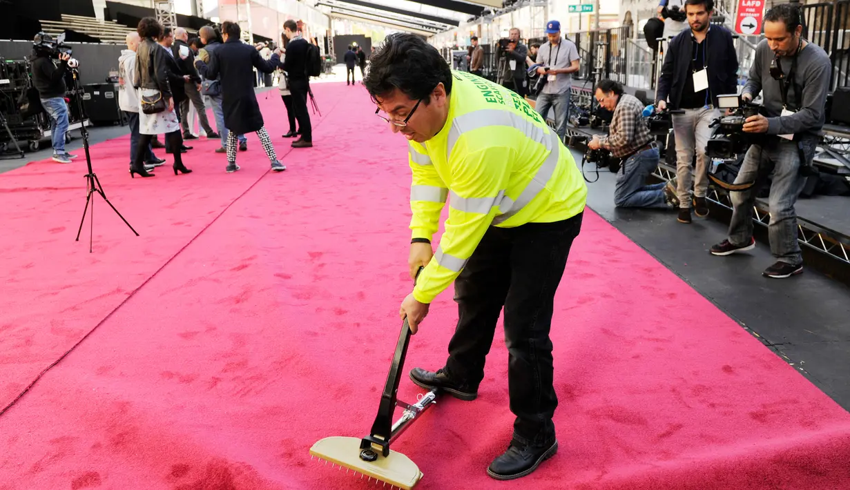Pekerja merapikan karpet merah untuk ajang Academy Awards ke-89 di depan Dolby Theatre, Hollywood, Los Angeles, 22 Februari 2017. Penganugerahan Oscar 2017 akan diselenggarakan pada Minggu (26/2) waktu setempat. (Photo by Chris Pizzello/Invision/AP)