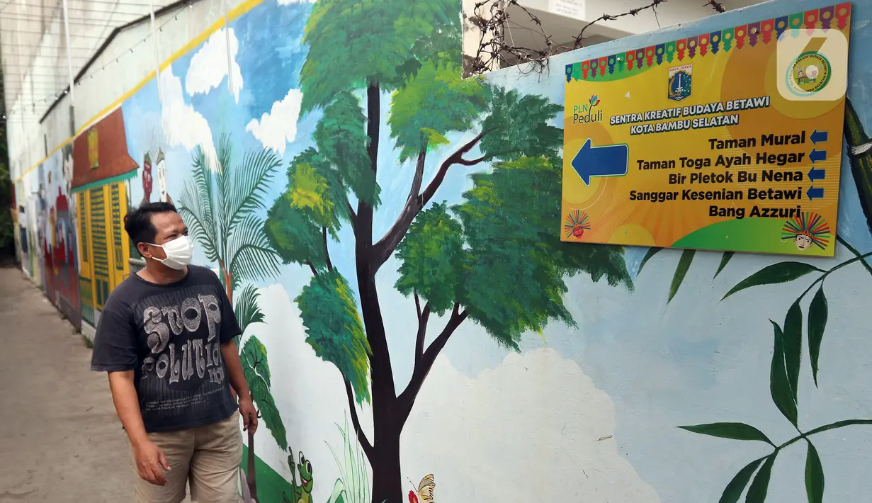 Warga melintas di depan mural bertema budaya Betawi di kawasan Kampung Sentra Kreatif, RW 006 Kota Bambu Selatan, Jakarta, Rabu (3/11/2021). Pengembangan kawasan ini juga untuk memberdayakan potensi perekonomian masyarakat, baik kuliner, jasa, dan tanaman obat. (Liputan6.com/Herman Zakharia)