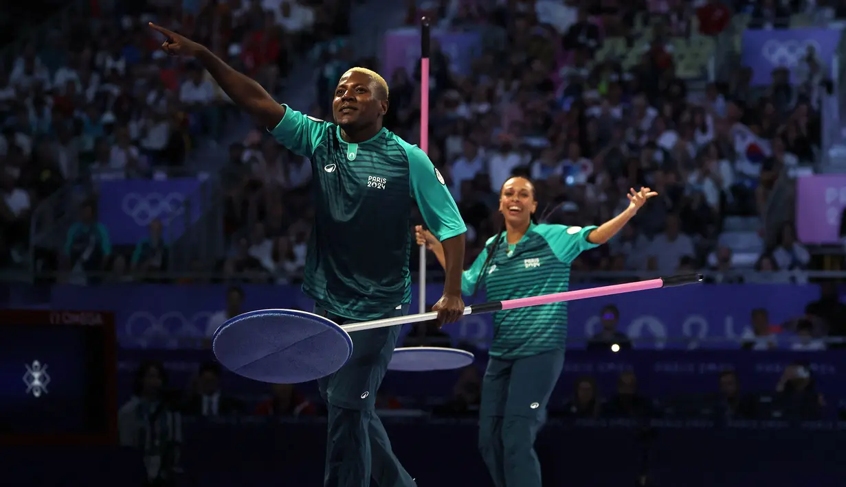 Dua orang volunteer mempersiapkan arena pertandingan perebutan medali perunggu taekwondo putri kelas -57kg Olimpiade Paris 2024 di Grand Palais, Paris, pada 8 Agustus 2024. (AFP/David Gray)