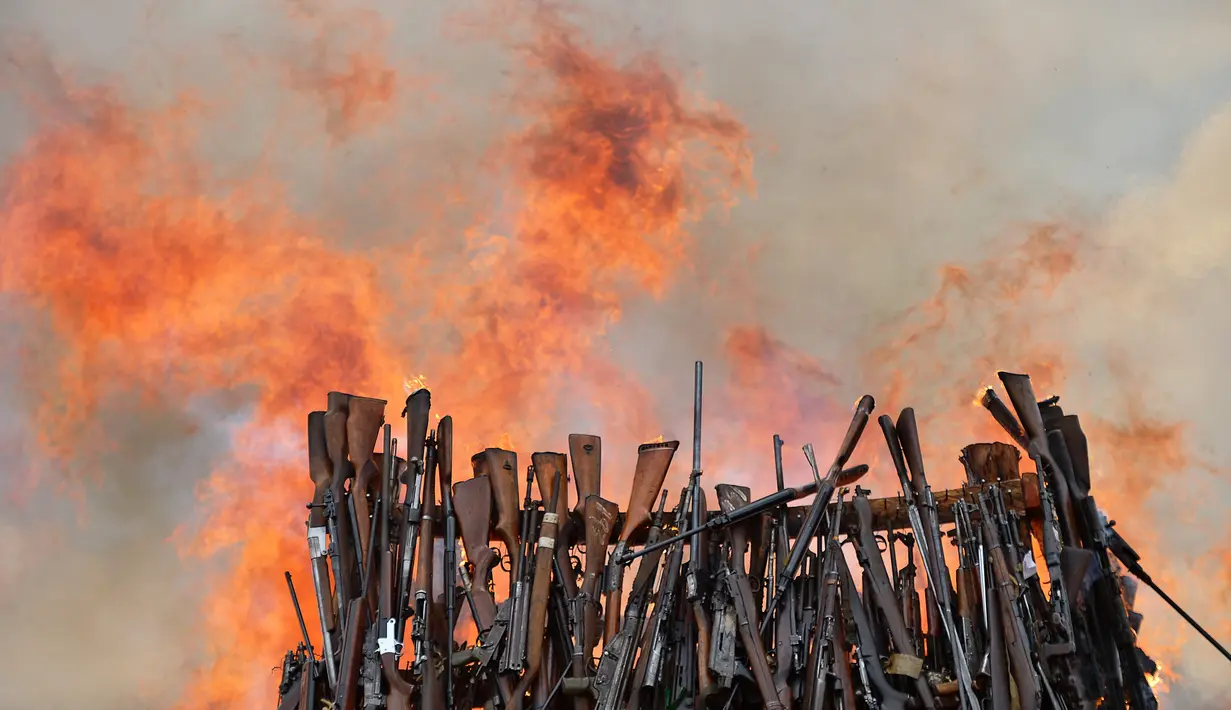 Senjata ilegal yang berhasil disita pihak keamanan Kenya dibakar di Kajiado County, Kenya (15/11). Pembakaran ini adalah upaya pemerintah Kenya untuk mengurangi tindak kejahatan yang mengunakan senjata api. (AFP/Tony Karumba)