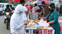 Warga memilih makanan untuk berbuka puasa (takjil) di kawasan Jalan Panjang, Jakarta, Selasa (5/5/2020). Pandemi virus COVID-19 dan pelaksanaan Pembatasan Sosial Berskala Besar (PSBB) berimbas pada sepinya pembeli takjil di kawasan tersebut. (Liputan6.com/Helmi Fithriansyah)