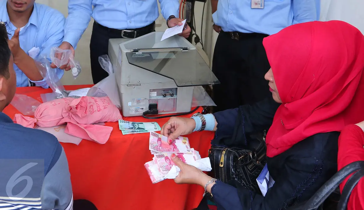 Warga menghitung uang yang akan ditukarkan dengan uang receh di penukaran uang keliling di Lapangan IRTI Monas, Jakarta, Senin (13/6). BI dan 20 bank umum membuka pelayanan penukaran uang di Monas dimulai 10 Juni 2016 kemarin. (Liputan6.com/Angga Yuniar)
