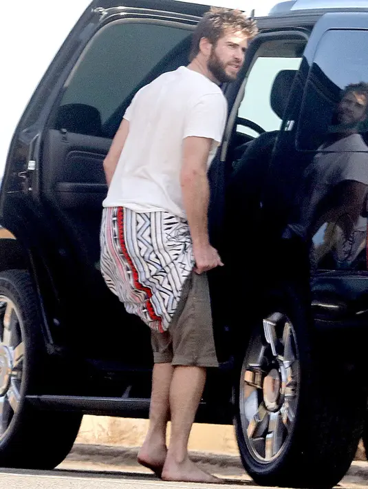 Setelah surfing, Liam Hemsworth tertangkap lagi ganti baju nih. Masih ganteng? (BACKGRID/US Magazine)