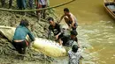 Petugas dibantu warga mengevakuasi buaya yang ditembak mati, karena diduga menerkam warga, dari sungai Kebuyahan di Desa Marukangan, Kalimantan Timur, Jumat (2/3). Anggota Polairud menembak mati untuk menghentikan aksi liar buaya itu. (AFP PHOTO/str)