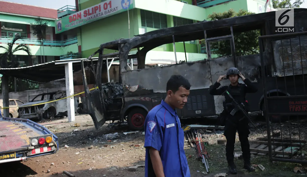 Pasukan Brimob bersiaga dekat bangkai sebuah bus yang terbakar di sekitar asrama Brimob Jalan KS Tubun, Petamburan, Jakarta Barat, Rabu (22/5/2019). Diketahui kerusuhan terjadi di lokasi tersebut, buntut demo depan gedung Bawaslu yang berujung ricuh. (Liputan6.com/Faizal Fanani)