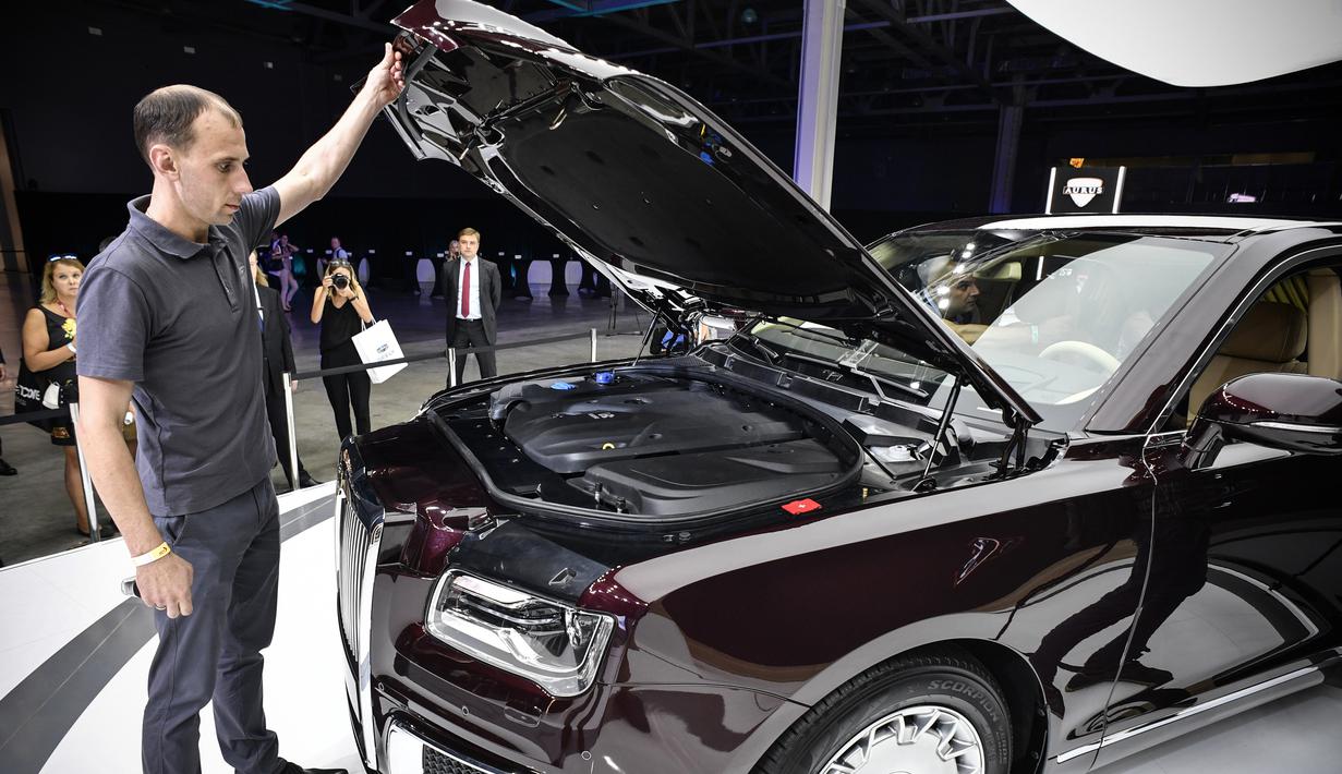 Pengunjung melihat bagian mesin mobil limosin Aurus Senat milik Presiden Rusia Vladimir Putin yang dipamerkan di Moscow International Motor Show di Moskow (29/8). (AFP Photo/Alexander Nemenov)