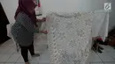 Warga menunjukkan motif kain batik di rumah susun (Rusun) Rawa Bebek, Jakarta, Sabtu (6/7/2019). Kain dengan motif Jakarta dan motif lainnya ini dibuat oleh ibu-ibu penghuni rusun Rawa Bebek, mereka menjualnya dengan harga Rp1,5 hingga Rp 2,5 juta per kain. (merdeka.com/Imam Buhori)
