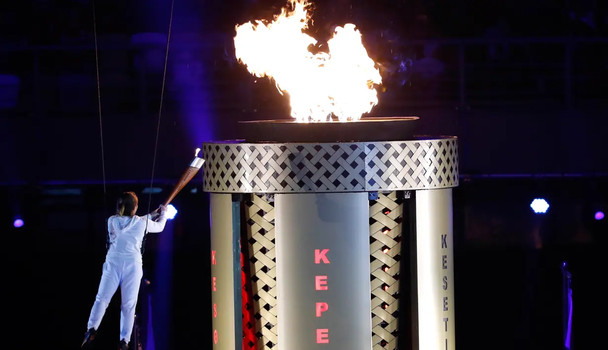 Seorang atlet menyalakan api obor Sea Games di dalam stadion saat Upacara Pembukaan Sea Games Asia Tenggara ke-29 di Kuala Lumpur, Malaysia, Sabtu, (19/08/2017). (AP Photo / Vincent Thian)