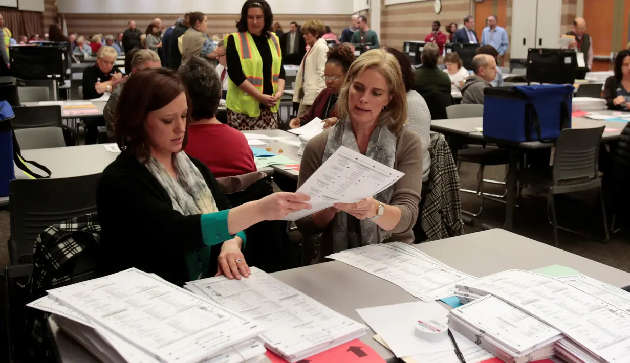 Petugas Oakland County menghitung ulang surat suara pemilihan Presiden AS di Waterford Township, Michigan, Amerika Serikat (5/12). Permintaan untuk menghitung ulang suara juga di serukan dari kubu Hillary Clinton. (Reuters/Rebecca Cook)
