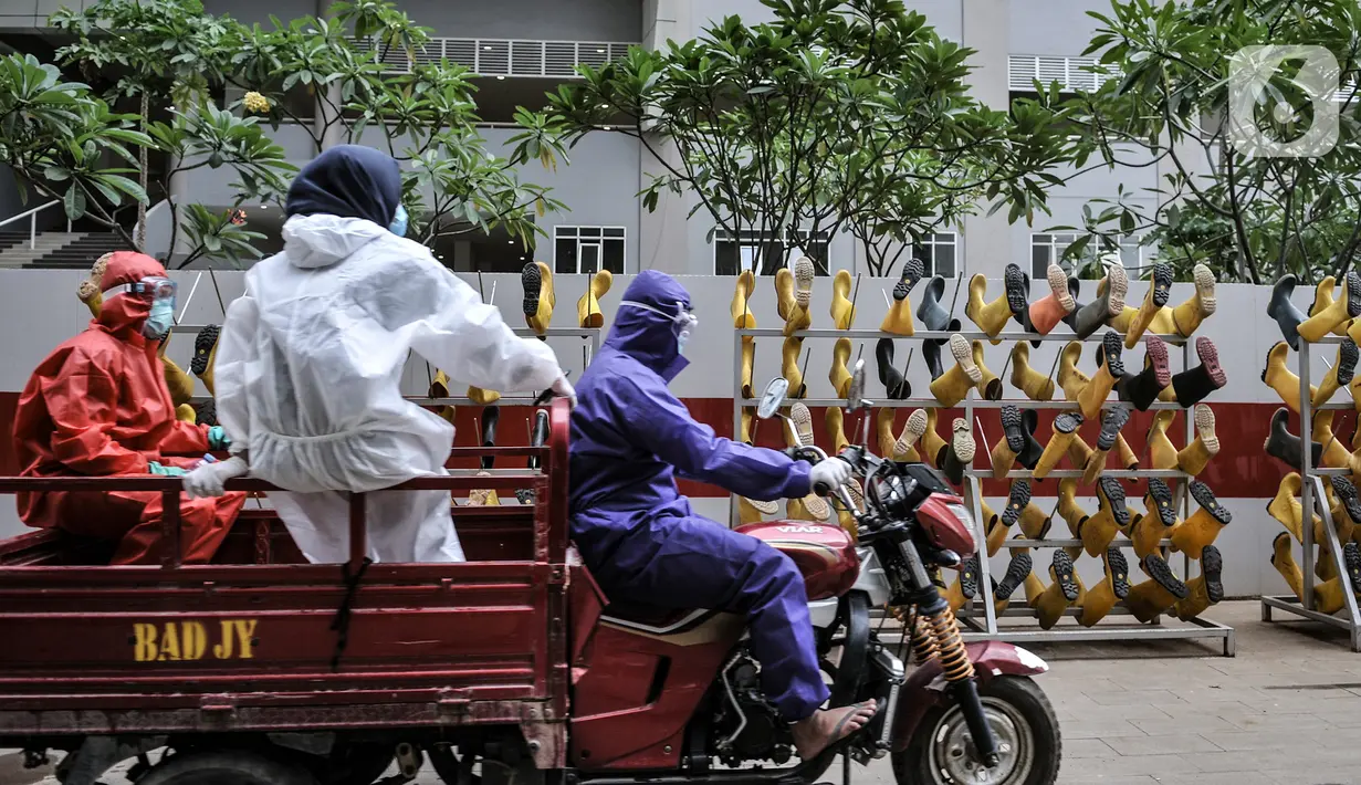 Rizky (33) bersama rekan Tim Sterilisasi menggunakan sepeda motor saat mengangkut sepatu tenaga kesehatan yang bertugas menangani pasien Covid-19 untuk dicuci di Rumah Sakit Darurat (RSD) Wisma Atlet Kemayoran, Jakarta. (merdeka.com/Iqbal Nugroho)