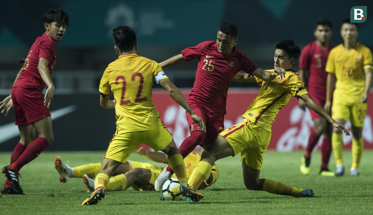 Gelandang Timnas Indonesia, Aulia Hidayat, berusaha melewati kepungan pemain China pada laga PSSI 88th U-19 di Stadion Pakansari, Jawa Barat, Selasa (25/9/2018). (Bola.com/Vitalis Yogi Trisna)