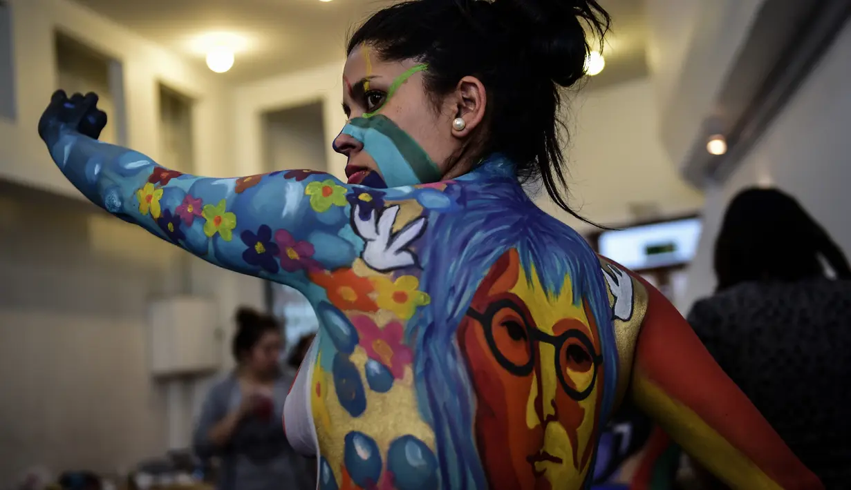 Gambar wajah John Lennon di tubuh seorang model saat pameran body painting, Santiago (24/11/2015). Lebih dari 100 desain yang terinspirasi oleh ikon musik, dipamerkan dalam pameran tersebut (AFP Photo/Martin Bernetti)