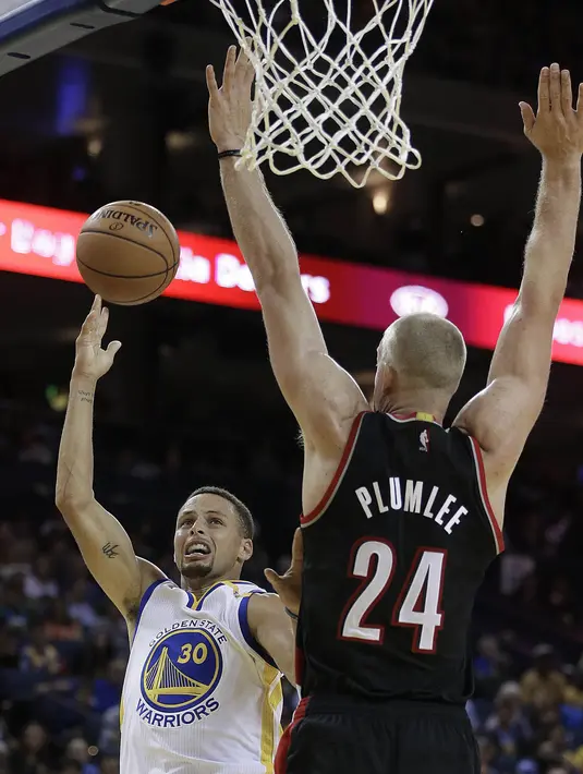 Pemain Golden State Warriors, Stephen Curry (kiri) melepaskan tembakan melewati pemain Portland Trail Blazers, Mason Plumlee #24 pada laga preseason NBA basketball game, Oakland, California, Sabtu (22/10/2016) WIB. Warriors 107-96. (AP/Ben Margot)
