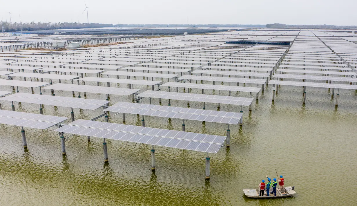 Teknisi listrik memeriksa panel-panel surya fotovoltaik di Wilayah Baoying, China (5/11/2020). Wilayah Baoying berupaya mengembangkan agrikultur ekologis melalui penggabungan budidaya ikan dengan pembangkit listrik tenaga surya, sebagai cara mendorong revitalisasi kawasan perdesaan. (Xinhua/Li Bo)