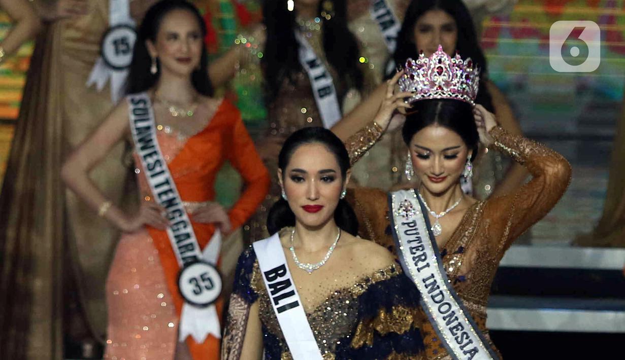 Puteri Indonesia 2020 Ayu Maulida Putri atau Ayuma mencopot mahkota untuk memasangkannya kepada Puteri Indonesia 2022 terpilih Laksmi Shari De Neefe Suardana saat Malam Puncak Grand Final Pemilihan Puteri Indonesia 2022 di Plenary Hall Jakarta Convention Center (JCC) Senayan, Jakarta, Jumat (27/5/2022). Laksmi Shari De Neefe Suardana terpilih menjadi Puteri Indonesia 2022. (Liputan6.com/Herman Zakharia)