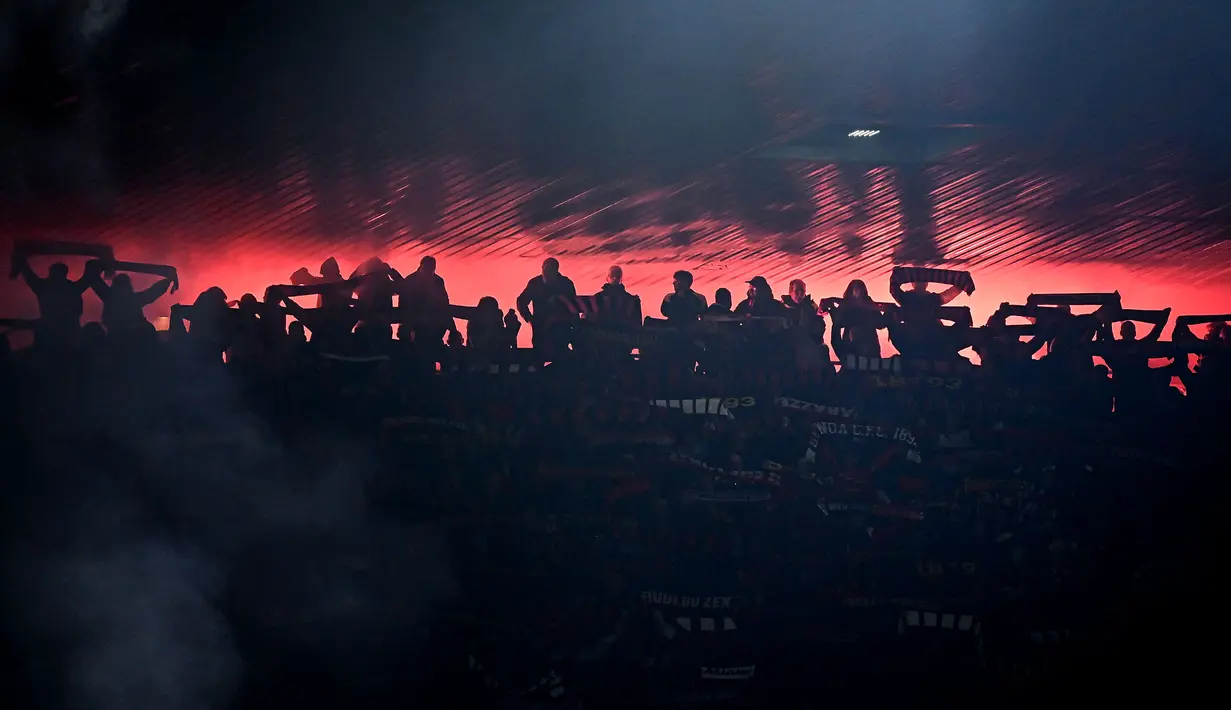 Siluet suporter Genoa saat menyaksikan laga lanjutan Liga Italia 2023/2024 melawan Inter Milan di Stadion Luigi Ferraris, Genoa, Italia, Sabtu (30/12/2023) dini hari WIB. (AFP/Piero Cruciatti)