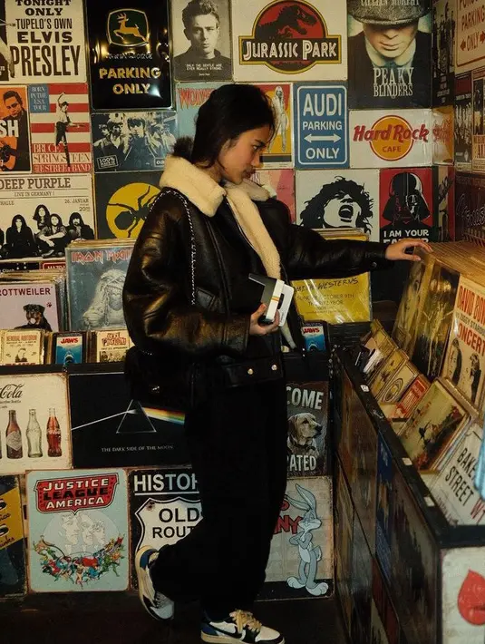 Azizah tampil dengan jaket kulit berbulu di bagian kerah dipadukan celana hitam yang serasi dengan sling bag dari Chanel, yang diperkirakan seharga Rp60 jutaan. [@azizahsalsha_]