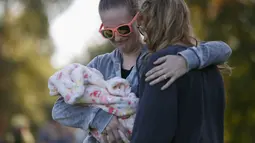 Dua wanita menangis melakukan aksi simpatik mengenang korban penembakan di Kampus Umpqua Community College di Roseburg, Sabtu (3/10/2015). Setidaknya 15 orang tewas dalam peristiwa tersebut. (REUTERS / Lucy Nicholson)