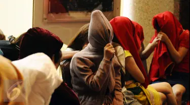 Puluhan perempuan warga negara asing illegal yang terjaring operasi pengawasan menutupi wajah saat rilis di Ditjen Imigrasi, Jakarta, Jumat (13/1). Diduga, para WNA tersebut bekerja sebagai pekerja seks komersial (PSK). (Liputan6.com/Helmi Fithriansyah)