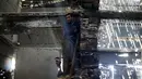 Seorang pria Palestina membantu seniman asal Belanda, Marjan Teeuwen, menciptakan sebuah karya arsitektur dari reruntuhan rumah yang hancur bekas perang pada 2014 di Khan Younis, selatan Jalur Gaza, 12 November 2016. (REUTERS/Ibraheem Abu Mustafa)