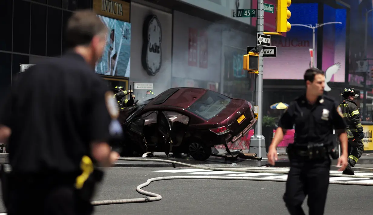 Petugas kepolisian berada dekat sebuah mobil yang menabrak para pejalan kaki di trotoar Times Square, New York, Kamis (18/5). Mobil tersebut melaju kencang ke arah jalur pejalan kaki dan menabrak kerumunan hingga menewaskan satu orang. (Jewel SAMAD/AFP)