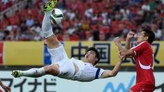Pemain Korea Selatan, Lee Jongho (kiri) mencetak gol dengan tendangan salto ke gawang Korea Utara dalam Turnamen Piala Asia Timur di Stadion Wuhan Sports Center, Wuhan, Tiongkok. (9/8/2015). (AFP Photo/Wang Zhao)