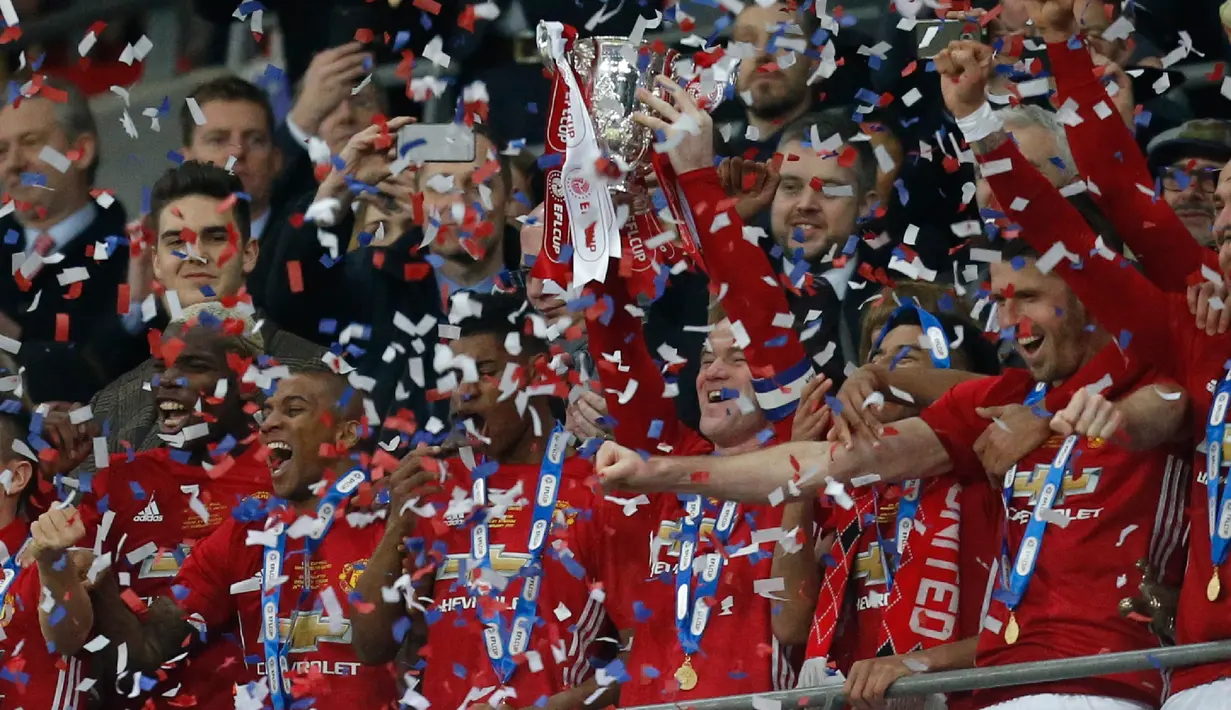Penyerang Manchester United, Wayne Rooney mengangkat Piala Liga Inggris, setelah mengalahkan Southampton dalam pertandingan final di Stadion Wembley, London, (27/2). MU menang atas Southampton dengan skor 3-2. (AFP Photo / Ian Kington)