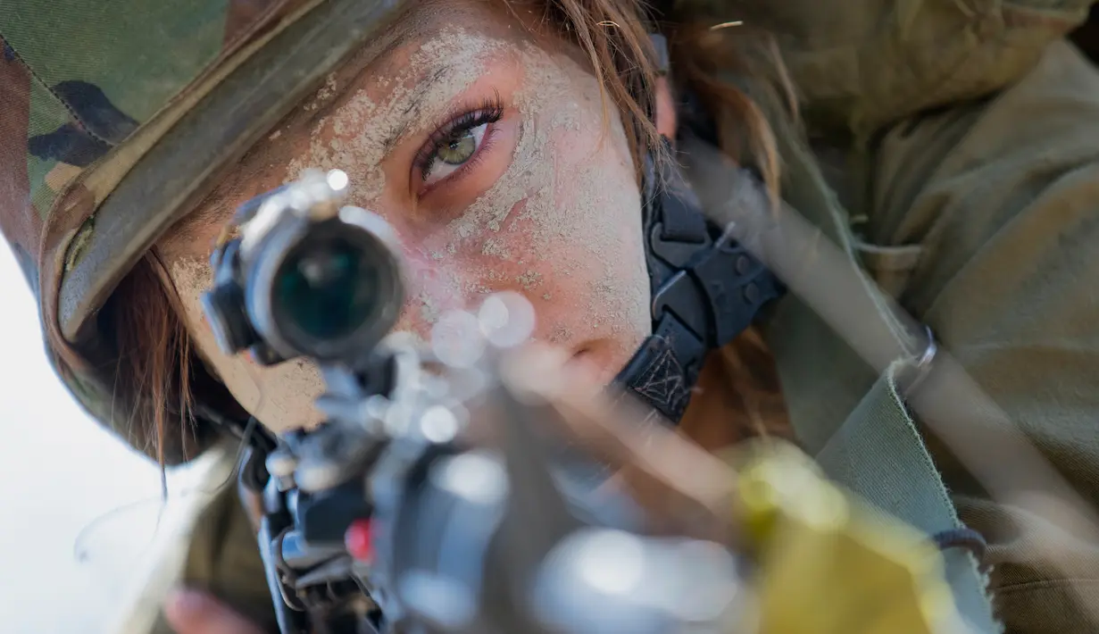 Seorang tentara wanita Israel dari Batalion Bardalas membidik musuh dengan senapannya saat latihan latihan perang di sebuah kamp militer, Yoqne'am Illit, Israel Utara, (13/9). Batalion Bardales resmi beroperasi pada Juli 2015. (AFP Photo/Jack Guez)