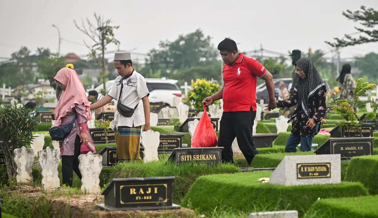 Umat Muslim mengunjungi makam kerabat mereka di sebuah pemakaman sebelum dimulainya bulan Ramadan, di Surabaya pada 27 Februari 2025. (JUNI KRISWANTO/AFP)