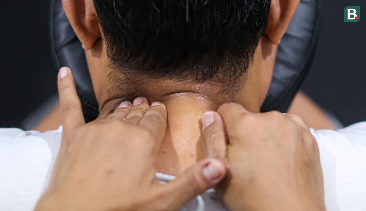 Seorang terapis sedang memijat jurnalis saat Piala Dunia FIBA 2023 di Indonesia Arena, Senayan, Jakarta, Jumat (01/09/2023). (Bola.com/Bagaskara Lazuardi)