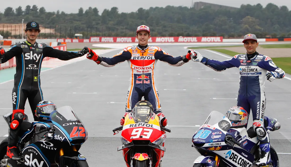 Juara Dunia MotoGP Marc Marquez (tengah) berpose bersama Juara Dunia Moto2 Francesco Bagnaia (kiri) dan Juara Dunia Moto3 Jorge Martin (kanan) usai Grand Prix Valencia di sirkuit Ricardo Tormo, Cheste, Spanyol, Minggu (18/11). (AP Photo/Alberto Saiz)