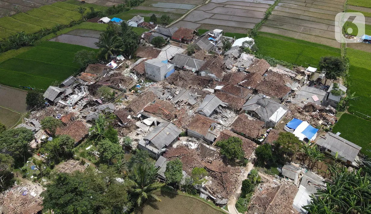 Foto udara memperlihatkan pemukiman yang hancur akibat gempa di Desa Sarampad, Kabupaten Cianjur, Jawa Barat, Selasa (22/11/2022). Kerusakan akibat gempa membuat kendaraan tidak bisa melintas untuk membawa bantuan bagi warga terdampak. (Liputan6.com/Herman Zakharia)