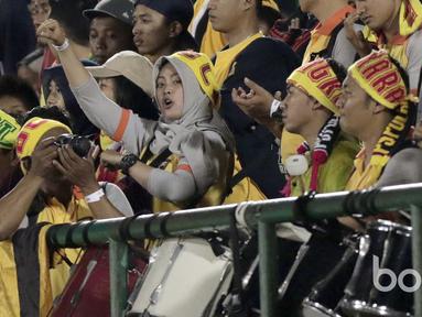 Aksi seorang Polwan bernyanyi mendukung timnya Bhayangkara FC saat melawan Semen Padang pada babak delapan besar Piala Presiden 2017 di Stadion Manahan, Solo, (26/2/2017). (Bola.com/Nicklas Hanoatubun) 