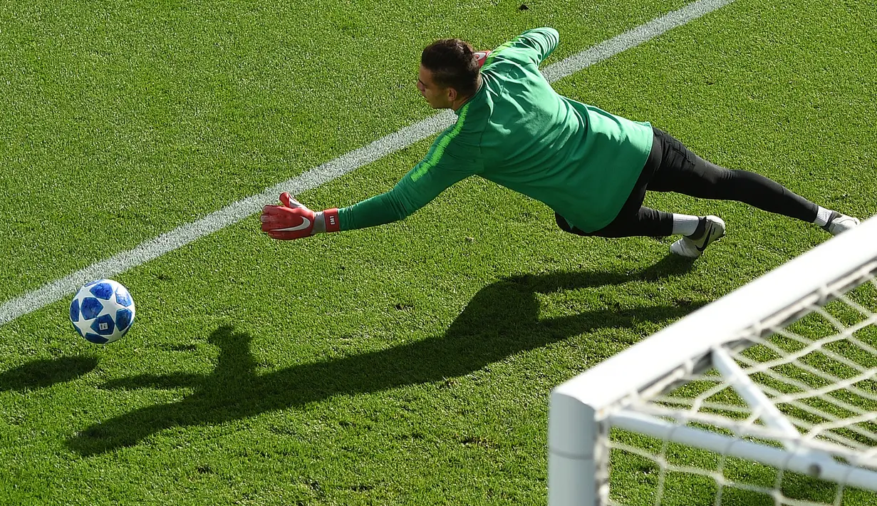 Kiper Manchester City,  Ederson berusaha menepis bola saat mengikuti latihan tim City Football Academy, Inggris (18/9). City akan bertanding melawan wakil Prancis, Lyon pada grup F Liga Champions. (AFP Photo/Oli Scarff)