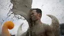 Seorang pria terkena lumpur saat bermain dalam Festival lumpur Boryeong di pantai Daecheon, Boryeong, Korea Selatan, (15/7). Festival lumpur Boryeong selalu mengadakan berbagai perlombaan yang menggunakan arena berlumpur. ( REUTERS/Kim Hong-Ji)